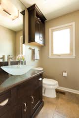 This small powder room got a makeover including a translucent vessel sink as an elegant touch.