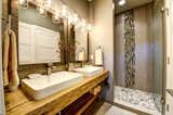 The guest suite bath features dual Kohler sinks, glass shower surround and stunning tile work.