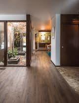 Entry showing the view all the way back to the dining and kitchen area with lots of light from the atrium. Note aggregate flooring at entry