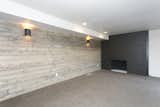 Basement Family room with wood accent wall and painted black brick fireplace.
