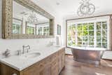 Bath Room, Medium Hardwood Floor, Engineered Quartz Counter, Pendant Lighting, Undermount Sink, Soaking Tub, Freestanding Tub, Enclosed Shower, and Ceiling Lighting Private rose garden views for ultimate relaxation while soaking.  Photo 18 of 38 in Magic in Malibu House by Nina Kurtz