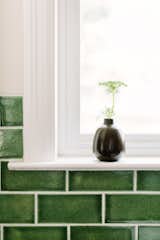 Kitchen, Stone Counter, Medium Hardwood Floor, Subway Tile Backsplashe, and White Cabinet A small bud vase from Heath Ceramics plays off of the Fireclay Tile subway pattern.   Photo 10 of 15 in Going Old School in The Bay Area by Julia Goodwin Design