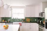 The bold green tile adds a vibrant touch to the home, mirroring the client's personality. 