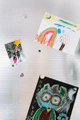 Sheet metal on the side of the fridge adds an industrial touch but allows for a rotating gallery wall for the children.