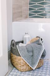 The addition of a basket brings warmth, texture, and additional storage to a small bathroom,