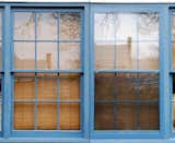 Storm windows, while never invisible, can have a reduced appearance if painted to match the existing window frames and if designed to fit flush with the window frame, rather than protruding out from the facade.  Photo 5 of 10 in How to Save Historic Windows on an Existing Property