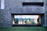 Windows A dark, almost black mortar on the lower portion of the home makes it feel grounded in the landscape.  Photos from These 4 Modern Homes Around the World Take Advantage of Local Stone