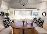 Melissa and Rusty Miller renovated their 1979 Airstream themselves, using recycled pallets for countertops and plywood for the dining area benches. In smaller spaces, it’s easy to get overpowered by bright colors and bold prints, so the Millers kept their palate simple and neutral, selecting accent pillows in a striking black and white pattern to make a statement. Small, understated mirrors bring in more light and even make the space feel a bit larger.