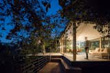 Exterior, Flat RoofLine, House Building Type, and Glass Siding Material At night, the home glows like a glass jewel box.  Photo 3 of 15 in A Portuguese Glass House Uses Surrounding Foliage as a Privacy Screen