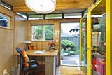 The interior of the she shed by Modern Shed features wood paneling and exposed beams. The prefabricated shed meant that it was ready to be used within a few days of its arrival on site.