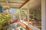 Outdoor, Small Patio, Porch, Deck, Shrubs, Trees, Front Yard, and Concrete Patio, Porch, Deck The front porch has just enough space for a seating area.  Photo 2 of 13 in A Midcentury Charmer in the Bay Area Is Listed at $749K