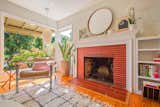 Living Room, Medium Hardwood Floor, Chair, Standard Layout Fireplace, Pendant Lighting, and Wood Burning Fireplace The living room also features a brick fireplace.  Photo 4 of 13 in A Midcentury Charmer in the Bay Area Is Listed at $749K