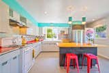 Kitchen, Refrigerator, Range Hood, Ceramic Tile Backsplashe, Pendant Lighting, and Range Period-appropriate lighting and bright colors keep the kitchen feeling vintage and yet contemporary.  Photo 6 of 13 in A Midcentury Charmer in the Bay Area Is Listed at $749K