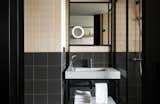 A bathroom in a guest room features a new take on traditional square two-tone tiles.
