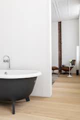 The main bathroom, with its black-and-white stand-alone tub, can be closed off with sliding doors.