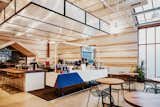 The light-filled, wood-clad flagship of Greater Goods Roasting in Austin features various types of seating including wood tables with black metal mesh chairs, wood benches, high stools, and plush armchairs and sofas.&nbsp;