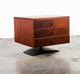 Known for his design-forward but unpretentious work, furniture designer Milo Baughman created this walnut veneer bedside table with a sculptural metal base, so that it almost appears to hover over the ground.
