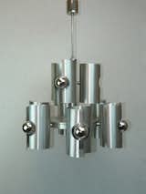 Comprised of nine asymmetrical cylinders of brushed aluminum set at different levels, this chandelier hails from France but ships worldwide. The three upper lights can be switched on separately from the six larger lights below. Each light is partially shaded by a sculptural, offset cylinder in brushed aluminum. We love how the mirrored bulbs really emphasize the reflective, circular nature of the fixture.