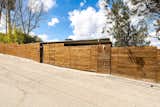 On the street-facing side, the home has a privacy fence made from wood and weathered steel.
