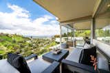 A glass guardrail on the outdoor terrace provides uninterrupted views of the valley below.