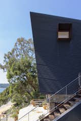 The home's punched windows are shaded by Cor-Ten steel.