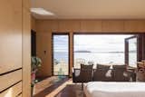 The bedroom takes advantage of ocean views with glazed doors and louvered windows.