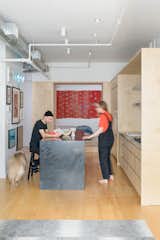 The open, 920-square-foot loft felt right to homeowners and creative couple Aubrey Ament and Will Glaser, but they needed to separate public and private spaces. A thick wall of storage did the trick.