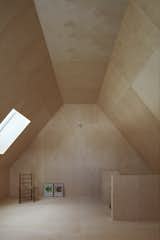 The gable roofs of the house are expressed on the second floor, where the lofted ceilings are covered with birch plywood.