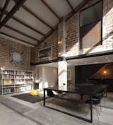 Modern steel structural elements contrast with the existing wood roof beams and trusses and brick columns and walls.