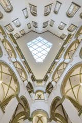 The geometry of the skylight reflects the shape of the courtyard itself and is inspired by the vaults of the arcade around it; the daylight still floods the space, allowing the green tile to contrast against the white walls.