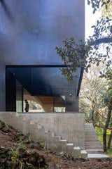 The two sets of concrete steps hug two sides of a void, allowing the open porch to retain two exposures.