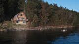 The home is surrounded on three sides by forest, and its most prominent facade faces the water. Its unique acorn shape efficiently sheds rain and snow, and creates an architecturally interesting interior space.