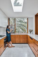 Louvered windows in the kitchen and bathroom provide natural ventilation. The floor and countertop have a natural, organic texture to them that ensures the space feels homey and modern rather than cold and clinical.
