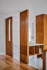 Vertical wood elements surrounding the staircase are emphasized by cables that stretch down to the lower level.