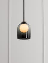 A smoky, fading black glass bell over a circular orb of light is an evocative, moody light fixture from Allied Maker.