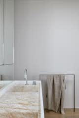 The bathroom features the same stone as the kitchen countertops, providing visual interest in the otherwise white bathroom.