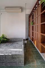 Bedroom, Terrazzo Floor, Bed, Bookcase, and Storage The master bedroom was divided into a long, narrow corridor with built-in cabinetry that acts as a porous divider.  Photos from Before & After: An Art Deco Apartment in Mumbai Becomes a Couple’s Creative Headquarters
