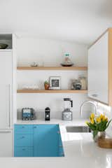 The light blue of the lower cabinetry was inspired by the color of the backyard pool, but was restricted to the lower cabinets to avoid overwhelming the space. The white counters, walls, and cabinets keep the space feeling light and bright, thanks to lots of natural daylight as well.