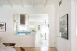 The kitchen's blue cabinetry act as a pop of color visible from the dining room, especially thanks to the enlarged opening between the two spaces.