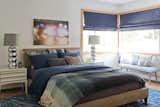 The tonal blues in the bedroom create a feeling of calm, while accessories like the reflective lamps bring a bit of glamour.  Photo 14 of 19 in Budget Breakdown: Restored for $364K, a Connecticut Artist’s Midcentury Home Stars Fieldstone Walls
