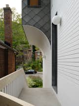 The curved orbs of the exterior lighting mimics the curves of the half-arch at the entryway.