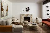 The living room features a number of contemporary pieces of art, contrasting with the more traditional Persian-style rug on the floor. The marble fire surround is a custom design.