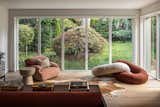 A second, more casual living area used as a family room -- complete with sculptural furniture -- was added to the rear. Floor-to-ceiling glazing brings in tons of natural light and allows for a direct connection to the outdoors.