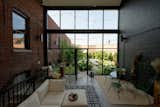 Views from the atrium allow Sarah and Dylan to appreciate the garden year-round, and also serves to physically connect the two buildings that border the garden. The brick building is the former book bindery, and the concrete block building now is the rental property.