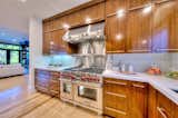 Kitchen, Quartzite Counter, Wood Cabinet, Light Hardwood Floor, Cooktops, Recessed Lighting, Mosaic Tile Backsplashe, and Range  Photo 4 of 10 in Beautifully Renovated Above Sunset by Campbell Wellman Properties