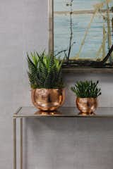 A painting from the Jenna Burlingham Fine Art gallery is complemented by the textured brass console and the hammered copper flower pots. 