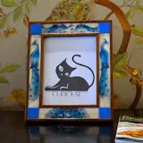 Relive your past memories by placing them into the exquisitely crafted Majestic peacock photo frame. A symbol of royalty, peacock is the national bird of India. The bird has a long history in the art and mythology of India. Peacock symbolized royalty and power which prompted the great emperor, Shah Jahan the builder of Taj Mahal to build the Majestic “Peacock Throne” in the early 17th century. The majesty, shimmer and the charming blue of the peacock are an inspiration behind the peacock photo frame. Crafted with teakwood with intricate miniature paintings of peacock made on the animal bones, which are inserted into this beautiful frame to showcase your memory and preserve them with the royal past of this timeless bird. The painting art form on this frame is a miniature painting art form which has been practiced by a clan of artist in southern Rajasthan of India.