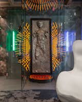 The final showcase piece is a life-size replica of Han Solo frozen in carbonite, dwelling in a custom glass display case and surrounded by Jedi lightsabers and helmets.