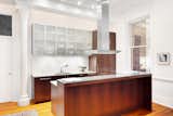 The home possesses an open windowed kitchen with large island, custom cabinetry, stainless steel appliances, and a large breakfast bar - an entertaining dream.