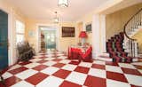 The foyer features a red & white checkerboard floor and a winding staircase to the second level